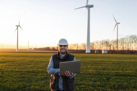Electrical engineers working at wind turbine power generator station with laptop Foto stock