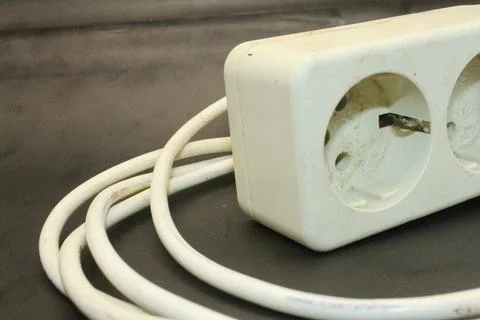 Electrical extension cord on a black background, closeup of photo Stock Photos