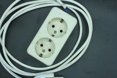 Electrical extension cord on a black background, closeup of photo Stock Photos