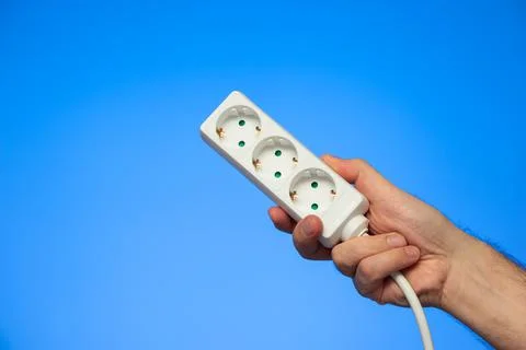 Electrical extension cord with multiple plug sockets held in hand by Caucasia 스톡 사진