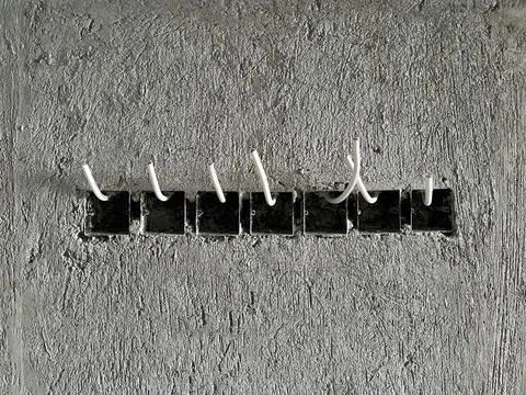 Electrical flush mounted socket junction boxes with installed white cables Stock Photos
