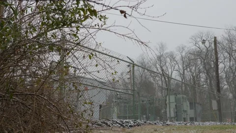 Electrical generator and chain link fence wide shot in snow fall 스톡 동영상 145195863