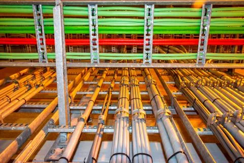 Electrical grey cables mounted in a rack for power supply in a industrial area Stock Photos