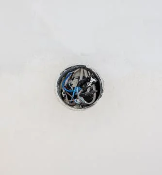 An electrical junction box on a white wall. The electrical wires start from the 库存照片