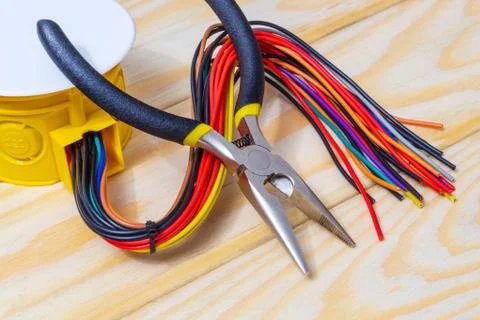 Electrical junction box with wires and tool on wooden boards usually used in Stock Photos