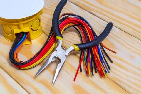 Electrical junction box with wires and tool on wooden boards usually used in Stock Photos