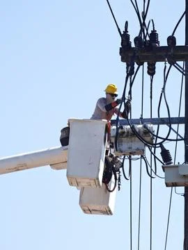 Electrical lineman team worker on hydraulic bucket truck lift performing. Stock Photos