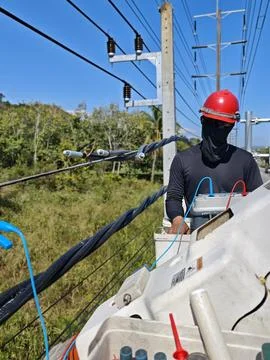 Electrical lineman testing insulation resistance of twisted aerial bundle. Stock Photos