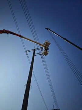 Electrical lineman worker team in mobile crane bucket lift replacing high volt. Stock Photos