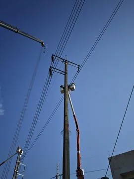 Electrical lineman worker team in mobile crane bucket lift replacing high volt. Stock Photos