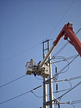 Electrical lineman worker team in mobile crane bucket lift replacing high volt. Stock Photos