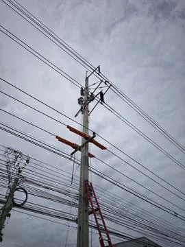 Electrical lineman worker team replacing high voltage suspension insulators.. Stock Photos