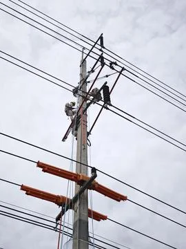 Electrical lineman worker team replacing high voltage suspension insulators.. Stock Photos
