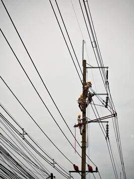 Electrical lineman worker team replacing high voltage suspension insulators.. Stock Photos