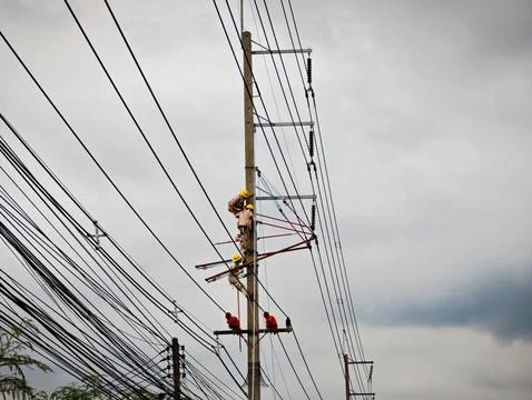 Electrical lineman worker team replacing high voltage suspension insulators.. Stock Photos
