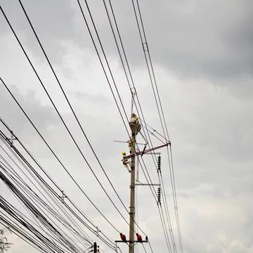 Electrical lineman worker team replacing high voltage suspension insulators.. Stock Photos