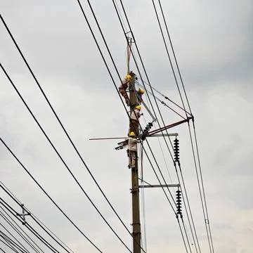 Electrical lineman worker team replacing high voltage suspension insulators.. Stock Photos