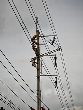 Electrical lineman worker team replacing high voltage suspension insulators.. Stock Photos