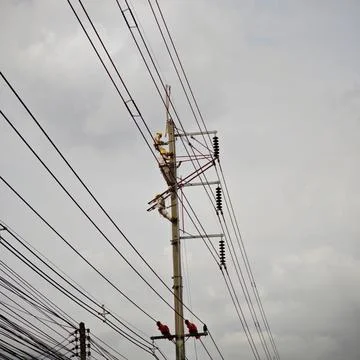 Electrical lineman worker team replacing high voltage suspension insulators.. Stock Photos