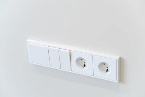 Electrical Outlet and Switch Panel on a Plain Wall in a Building Interior Stock Photos