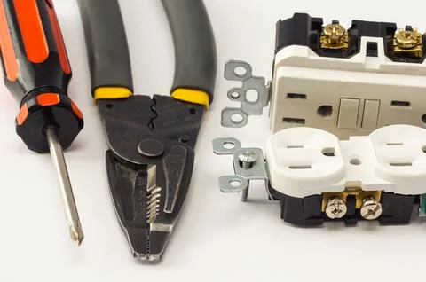 Electrical outlet, screwdriver and wire stripper tools on white background Stock Photos