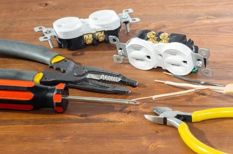 Electrical outlet, screwdriver and wire stripper tools on white background Stock Photos