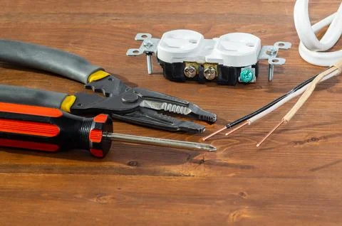 Electrical outlet, screwdriver and wire stripper tools on white background Stock Photos