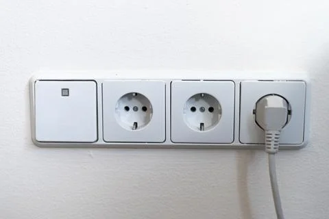 Electrical outlets and light switch on the wall Stock Photos