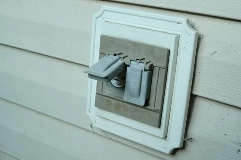 Electrical outlets with protective covers in the backyard of the house. Stock Photos