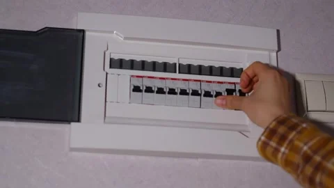 Electrical panel in the apartment. Fuse box. Hand switching power switch on a Stock Footage 169277743