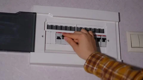 Electrical panel in the apartment. Fuse box. Hand switching power switch on a Stock Footage 169744036