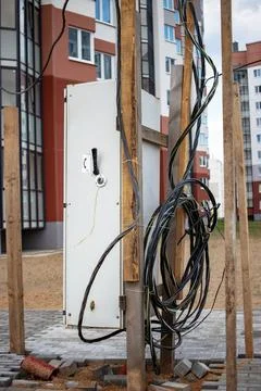 An electrical panel is being installed at a construction site, surrounded by Stock-Fotos