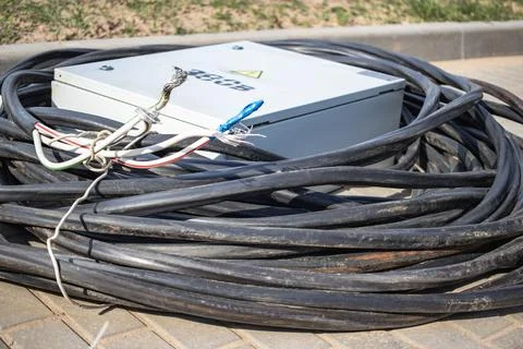 An electrical panel rests on the ground surrounded by cables, ready for insta 스톡 사진