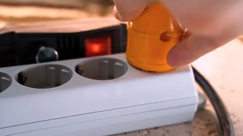 Electrical plug is inserted into the outlet. Power switch. Red tumbler Stock Photos