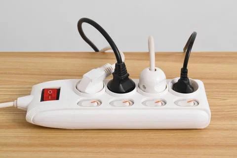 Electrical plug in outlet socket at home isolated on on wooden table 写真素材