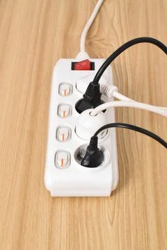 Electrical plug in outlet socket at home isolated on on wooden table Stock Photos