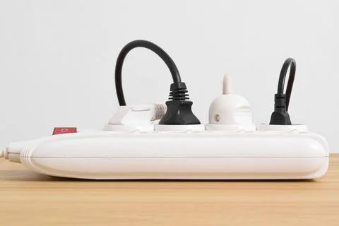 Electrical plug in outlet socket at home isolated on on wooden table Stock Photos