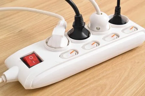 Electrical plug in outlet socket at home isolated on on wooden table Stock Photos