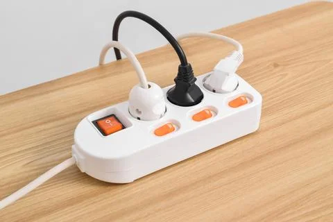 Electrical plug in outlet socket at home isolated on on wooden table Stock Photos