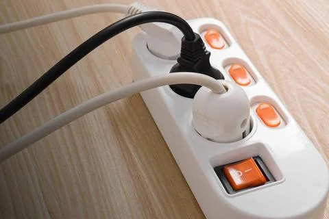 Electrical plug in outlet socket at home isolated on on wooden table Stock Photos