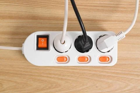 Electrical plug in outlet socket at home isolated on on wooden table Stock Photos