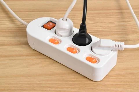 Electrical plug in outlet socket at home isolated on on wooden table Stock Photos