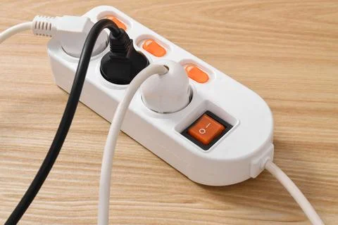 Electrical plug in outlet socket at home isolated on on wooden table Stock Photos