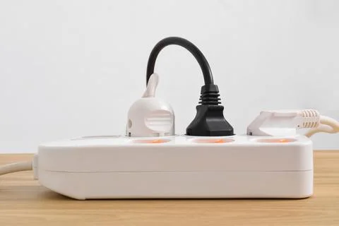 Electrical plug in outlet socket at home isolated on on wooden table Stock Photos