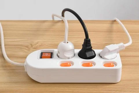 Electrical plug in outlet socket at home isolated on on wooden table Foto stock