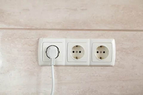 Electrical plug in outlet socket at home. Stock Photos