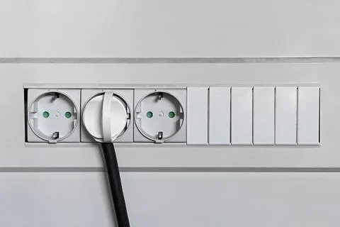 Electrical plug is plugged into the wall outlet close-up Stockfoto's