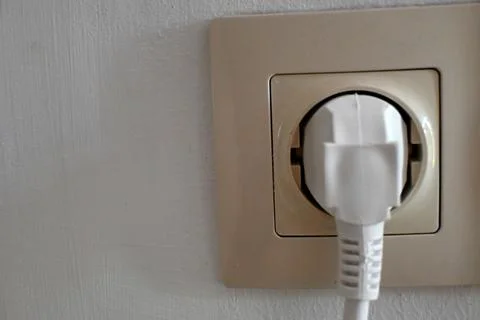 Electrical plug in a wall outlet Stock Photos