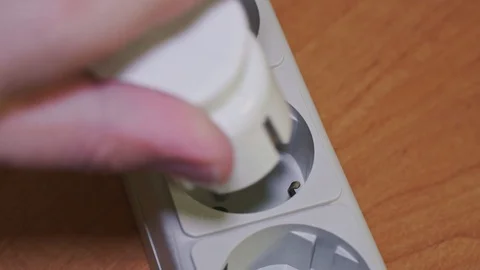 Electrical plugs and wattmeter are inserted into an electrical extension cord Stock Footage 103407312