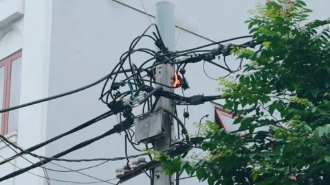 Electrical pole having a short circuit, sparking and burning power lines, Stock Footage 335644421